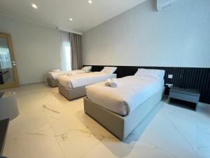 a hotel room with two beds with white sheets at Mayfair by Premier Suites MT in Is-Swieqi