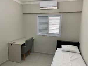 利梅拉的住宿－Apartamento próximo ao Pão de Açúcar e centro，一间卧室配有一张床、一张书桌和一个窗户。