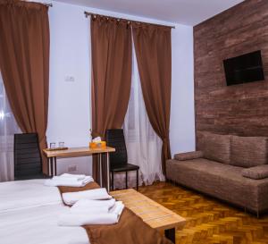 シビウにある4Rooms Central Sibiuのベッドとソファ付きのホテルルーム