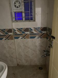 a bathroom with a shower with a window and a toilet at SSV stays in Bangalore