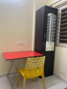 a table and a chair next to a table and a door at SSV stays in Bangalore