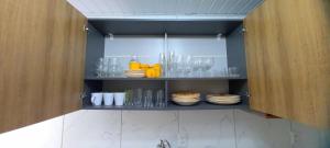 une armoire remplie de verres et d'assiettes dans la cuisine dans l'établissement Casa totalmente climatizada, à São Lourenço do Sul