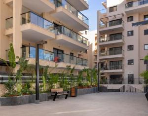 an apartment building with a bench in front of it at סוויטה מרווחת, רומנטית ומפנקת in Eilat