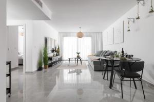 a white living room with a table and a couch at סוויטה מרווחת, רומנטית ומפנקת in Eilat