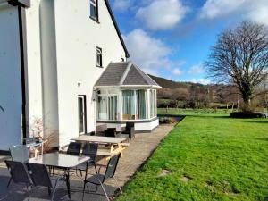 a white house with a picnic table and chairs at Killarney Farm House. in Killarney