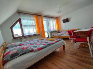 科尔别卢夫Panorama的一间卧室，有两张床、一张桌子和几把椅子