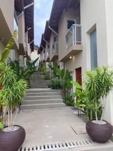 a hallway of a building with palm trees and stairs at Linda Casa em uma linda praia - Santiago/ Maresias in São Sebastião