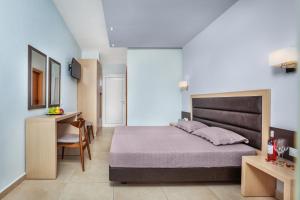 a bedroom with a large bed and a desk at Iris Hotel in Siviri