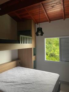 a bedroom with a bed and a window at Linda Casa em uma linda praia - Santiago/ Maresias in São Sebastião +51 photos