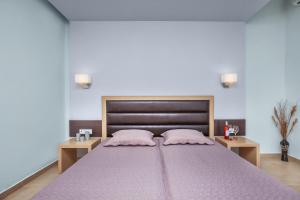 a bedroom with a large bed with pink pillows at Iris Hotel in Siviri