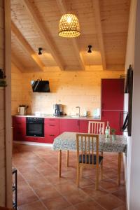 a kitchen with red cabinets and a table and chairs at Chalet Charmant-Santelmann in Bischoffingen