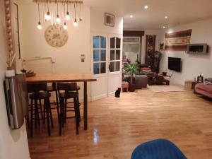 eine Küche und ein Wohnzimmer mit einem Tisch und Stühlen in der Unterkunft OFFRE SPECIALE JO AVEC TRANSPORT GRATUIT SUR DEMANDE Chambre privée dans grande maison de ville avec jardin in Wattrelos