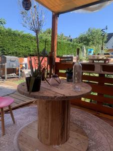 uma mesa de madeira com uma garrafa em cima em Chambre privée dans grande maison de ville avec jardin em Wattrelos