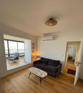 ein Wohnzimmer mit einem Sofa und einem Tisch in der Unterkunft Penthouse / 2 bedrooms in city center of Angers in Angers
