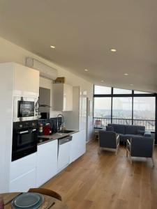 eine Küche mit weißen Schränken und ein Wohnzimmer in der Unterkunft Penthouse / 2 bedrooms in city center of Angers in Angers