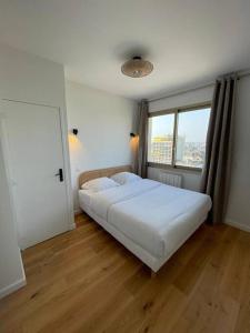 ein Schlafzimmer mit einem weißen Bett und einem Fenster in der Unterkunft Penthouse / 2 bedrooms in city center of Angers in Angers
