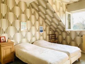 een slaapkamer met 2 bedden en een gestreepte muur bij Piriac, maison familiale, accès direct plage, 12 couchages in Piriac-sur-Mer