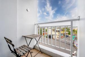 a chair on a balcony with a view of a street at H& Sunset Mu Style Inn in Xiaoliuqiu