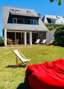 een huis met stoelen en een rode deken in de tuin bij Piriac, maison familiale, accès direct plage, 12 couchages in Piriac-sur-Mer