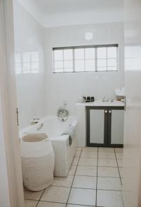 a white bathroom with a tub and a sink at @Kruger in White River
