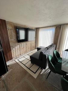 a living room with a couch and a flat screen tv at Casa Da Eira in Santo Emilião