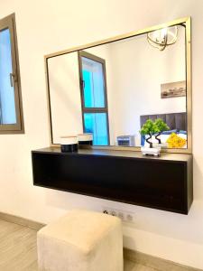 a large mirror on a wall with a stool in front of it at Apt Raffiné Taghazout Bay Vue Océan luxe 6p in Tamraght Ouzdar