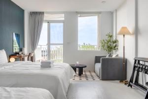 - une chambre avec un lit, une chaise et une fenêtre dans l'établissement H& Sunset Mu Style Inn, à Île Lamay