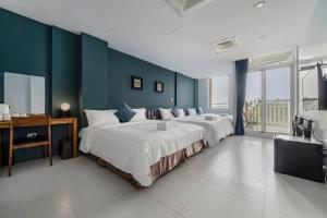 a bedroom with two beds and a blue wall at H& Sunset Mu Style Inn in Xiaoliuqiu
