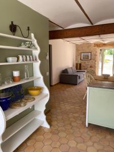 a kitchen with white shelves and a living room at L'Usine en Provence in Salernes