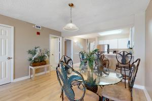 a dining room and kitchen with a glass table and chairs at The Resorts Of Pelican Beach 1413 Destin (Condo) in Destin