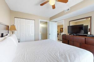 a bedroom with a white bed and a flat screen tv at The Resorts Of Pelican Beach 1413 Destin (Condo) in Destin +32 photos