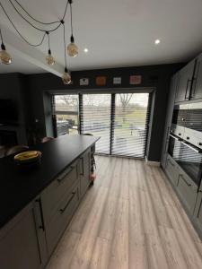 Il comprend une cuisine dotée de parquet et d'une grande fenêtre. dans l'établissement Beautiful Modern Farm House (12), à Sheffield