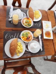 een tafel met borden met ontbijtproducten en -dranken bij HOSTAL TERO REAL in Puerto Villamil