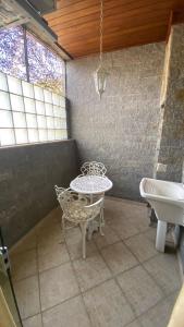 a bathroom with a table and a tub and a sink at Pousada Emaús in Cruzeiro