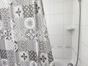 a shower curtain in a bathroom with a tub at Comfy Guest House in London