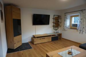 a living room with a flat screen tv on the wall at Apartments Edinger in Söll