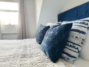 Una cama con almohadas azules y blancas. en No 8 Mathis self-service B&B en Salisbury