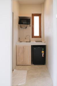uma pequena cozinha com um lavatório e um frigorífico em Nymph Hideout em Ko Phangan