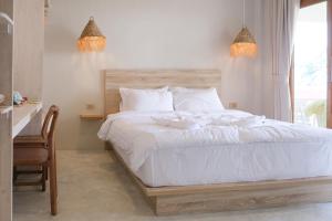 1 dormitorio con 1 cama con sábanas blancas y ventana en Nymph Hideout, en Ko Pha Ngan