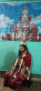 a woman sitting on the floor in front of a wall at Aajanta in Tawang