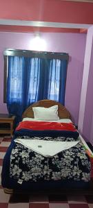 um quarto com uma cama com uma cortina azul em Aajanta em Tawang