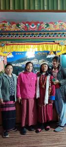 un gruppo di donne che si trovano davanti a un palco di Aajanta a Tawang