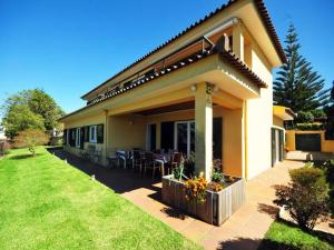 a house with a table and chairs in a yard at Superb Caminha Villa - 5 Bedrooms - Villa Davidouro - Spectacular Sea and Beach Views in Caminha