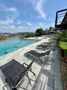 - une rangée de chaises assises à côté de la piscine dans l'établissement Pousada Villa Shalom, à Igaratá