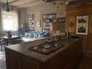 a kitchen with a stove and a living room at Uzupis Angel 3 bedroom Apartment in Vilnius