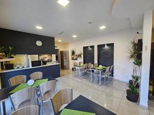 a restaurant with tables and chairs and a kitchen at Hotelik SJ - bezkontaktowe zameldowanie in Łódź