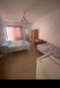 a room with two beds and a table in it at Ajsi Apartments in Durrës