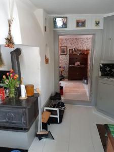 a living room with a stove and a kitchen at Charming renovated seventeenth century cottage in Ludvika