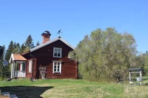 een oud huis met een schoorsteen erop bij Charming renovated seventeenth century cottage in Ludvika