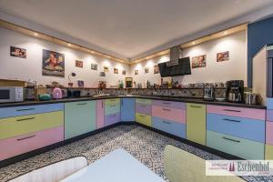 cocina grande con armarios y electrodomésticos coloridos en Eschenhof Quartier, en Bergheim